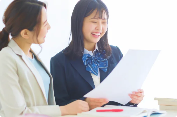 講師と生徒がプリントを見ながら笑顔で話している画像