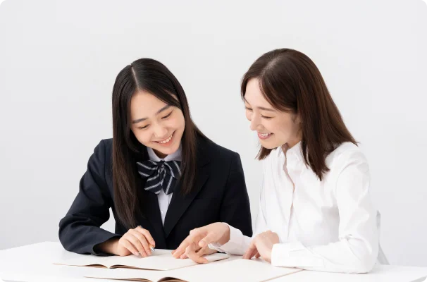 講師が生徒に机に置かれたテキストを見ながら話している様子