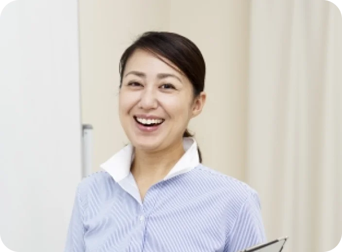 青いシャツの女性が笑っている画像